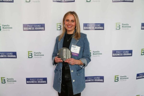 Missy Claridge, owner of Von's 1000Spirits, holds an award at the Puget Sound Business Journal Family Business of the Year Award ceremony