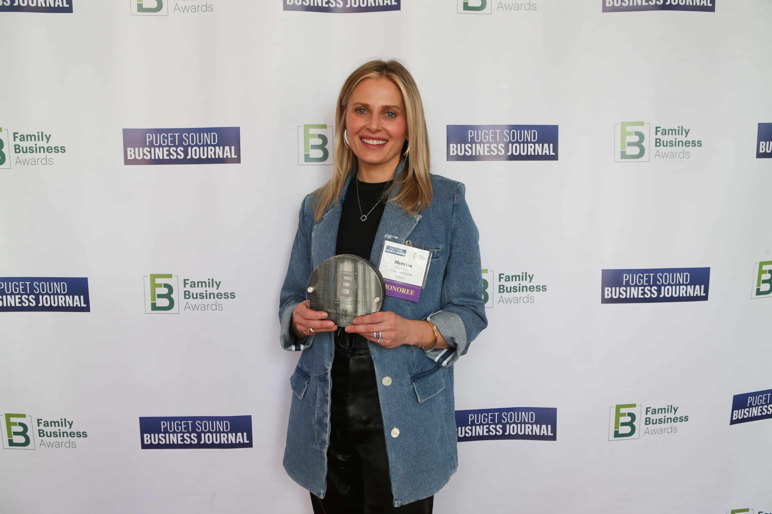 Missy Claridge, owner of Von's 1000Spirits, holds an award at the Puget Sound Business Journal Family Business of the Year Award ceremony