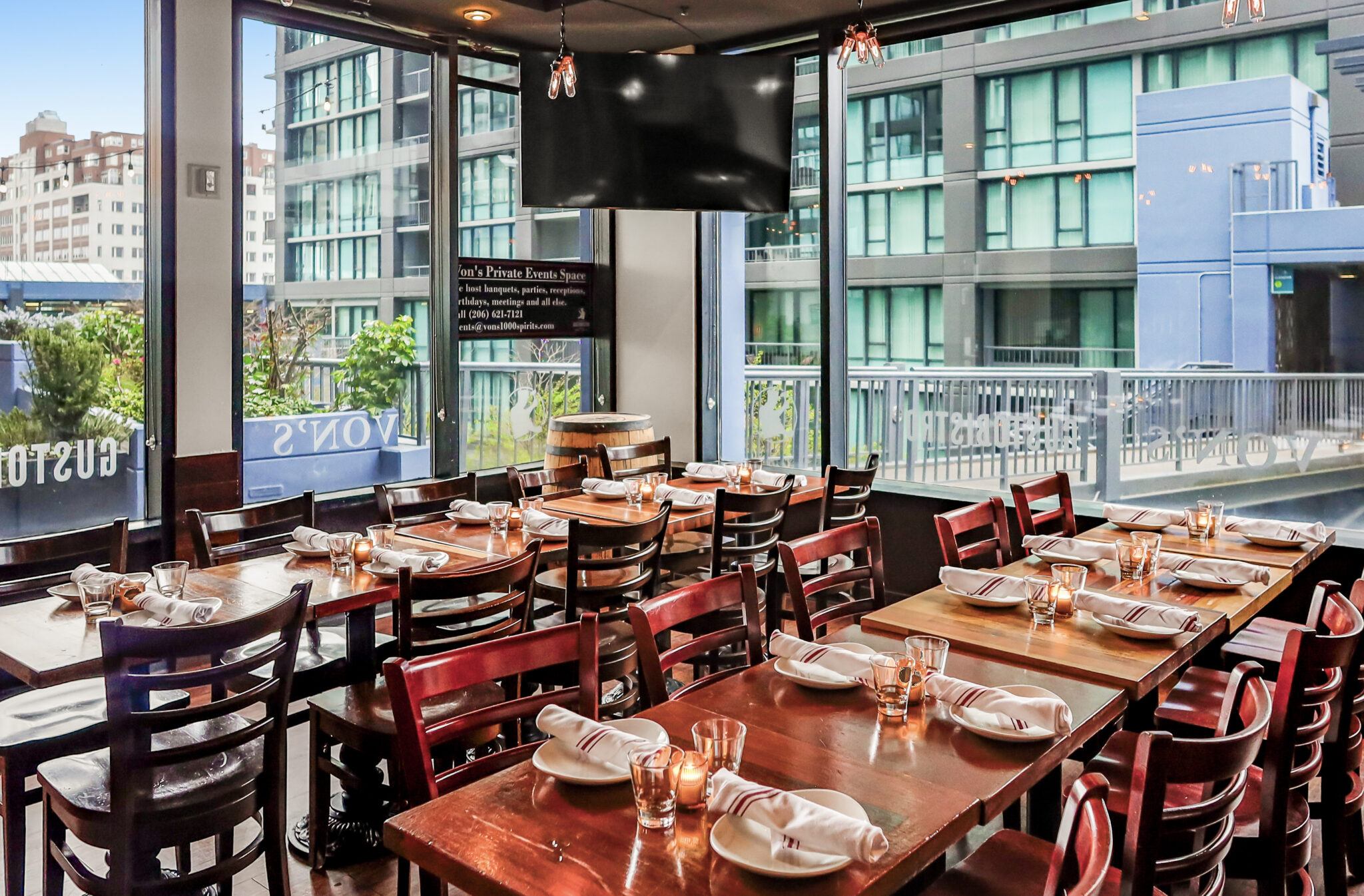 Von’s 1000Spirits private dining room in Seattle with set tables and floor-to-ceiling windows