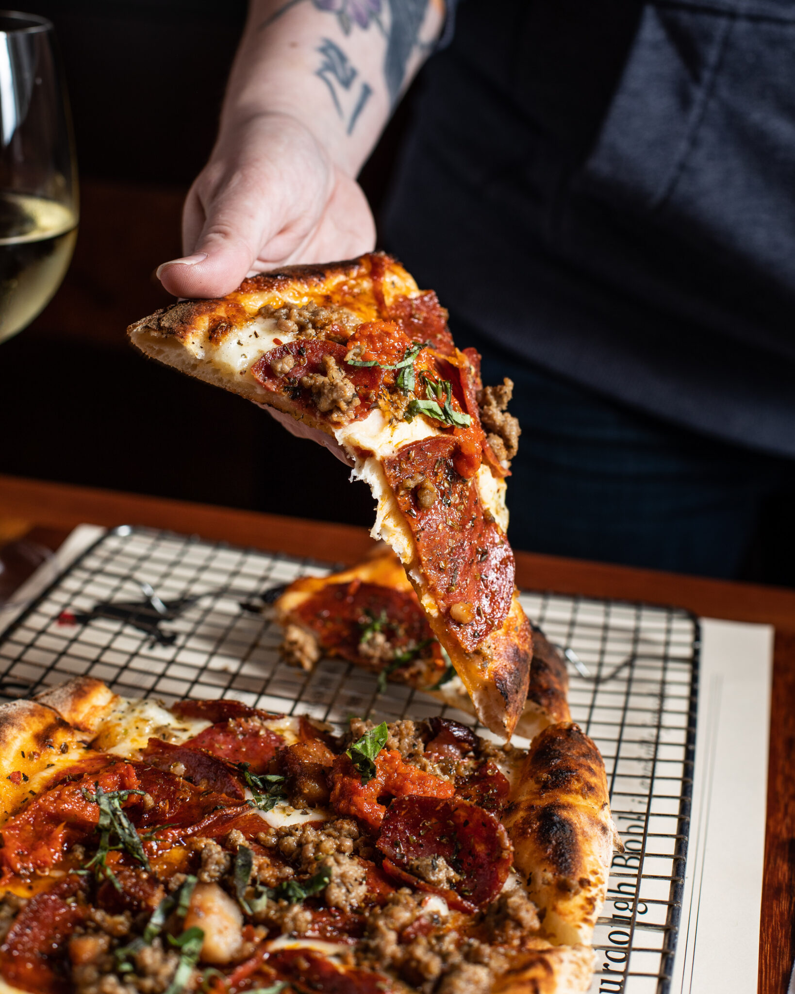 Quatre Viande four meat sourdough pizza with pepperoni, sausage, and fresh herbs